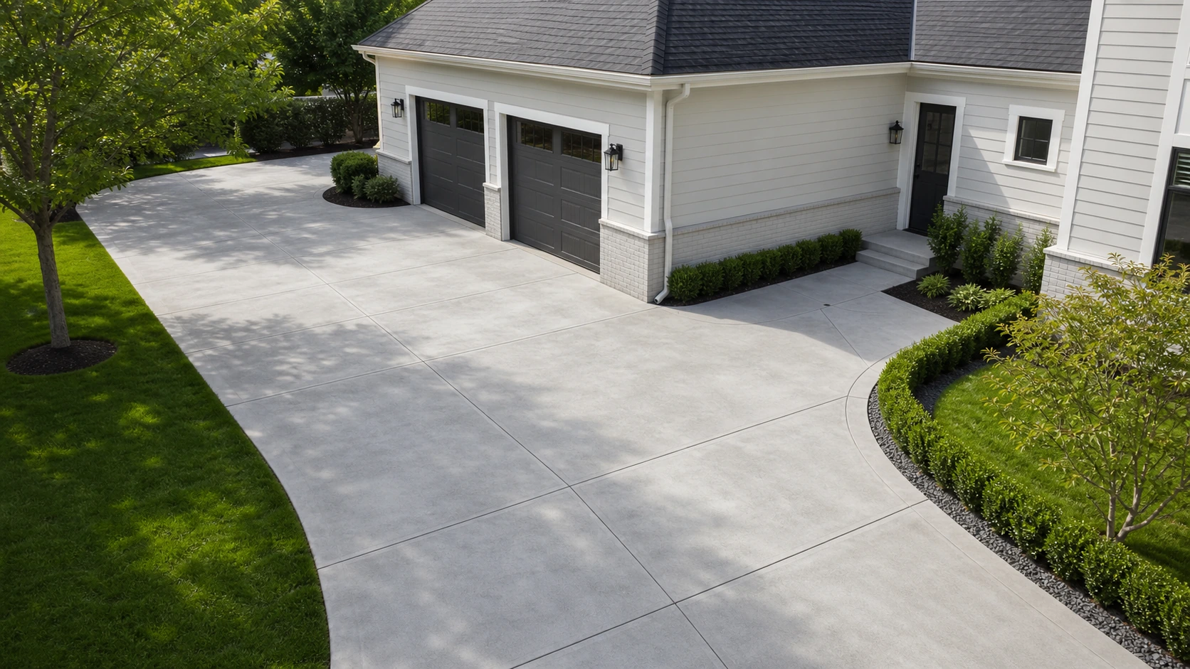 Side-entry garage with a widened concrete motor-court apron for turning and guest parking.