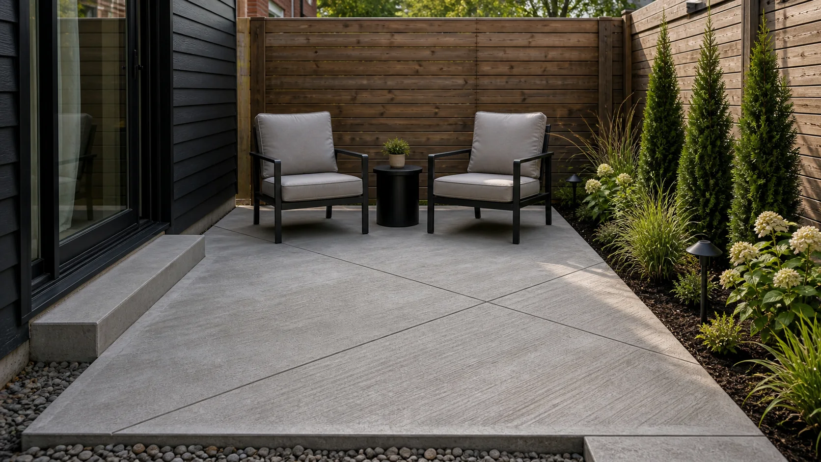 Small concrete patio with diagonal saw-cut joints and a compact lounge setup.