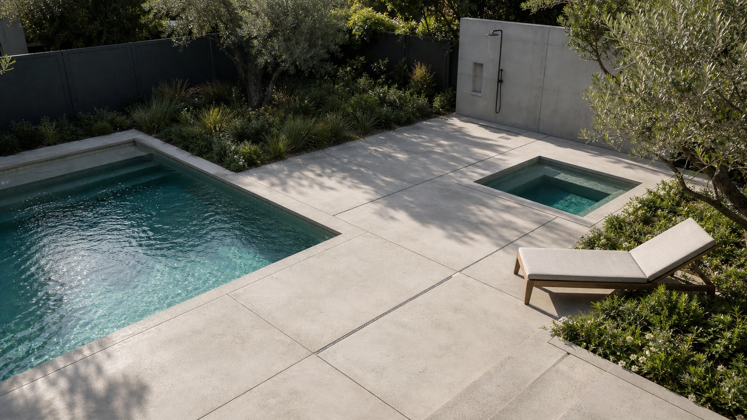 Wellness-oriented concrete pool retreat with a small cold-plunge zone, shower wall, and quiet lounge seating.